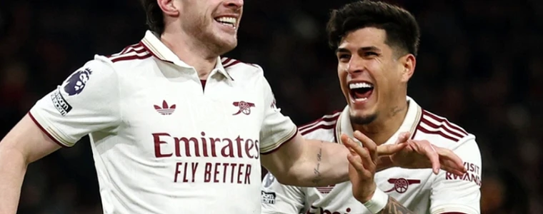 Áo đấu đỏ của Arsenal và áo xanh của Manchester City đặt cạnh cúp bạc trên sân cỏ trước trận Siêu cúp Anh 2026 tại Cardiff